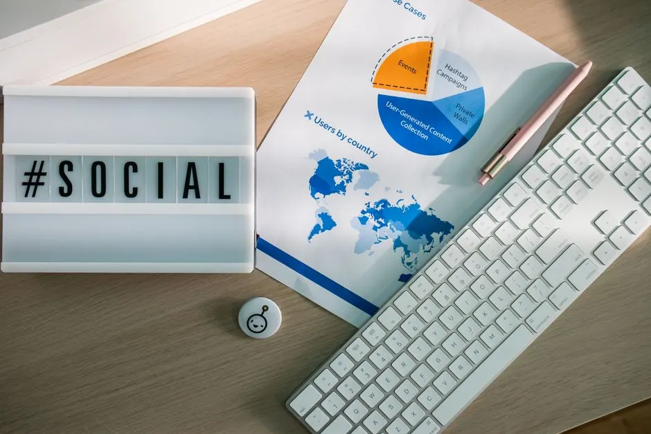 Social media sign beside a keyboard and printed charts