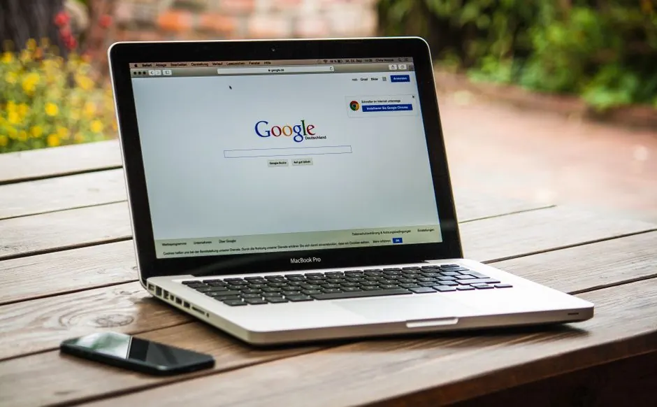Laptop open to a Google search on a wooden table
